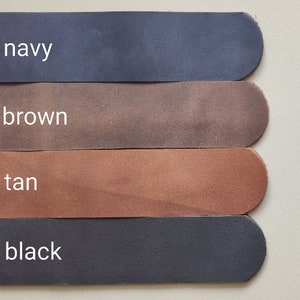May include: Four leather strips in different colours: navy, brown, tan, and black. The strips are arranged vertically, with the navy strip at the top and the black strip at the bottom.