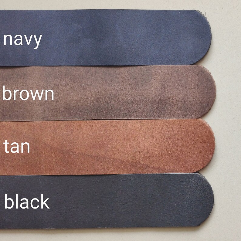 May include: Four leather strips in different colours: navy, brown, tan, and black. The strips are arranged vertically, with the navy strip at the top and the black strip at the bottom.