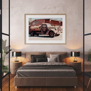 Puede incluir: Una fotograf&iacute;a enmarcada de un cami&oacute;n vintage oxidado con un tanque de agua, estacionado frente a un edificio. El cami&oacute;n tiene el n&uacute;mero "25" pintado en el lateral.