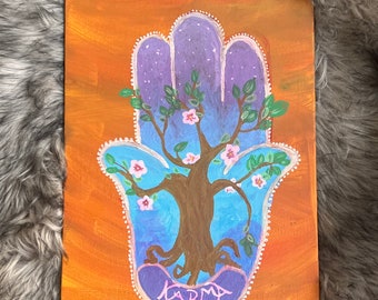 KARMA painting featuring hamsa healing hand and cherry blossom tree with orange backdrop
