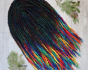 May include: A set of synthetic dreadlocks featuring a color gradient that transitions from deep black and dark forest green at the top to a vibrant rainbow spectrum of blue, green, yellow, orange, and red at the tapered ends, with small beads.