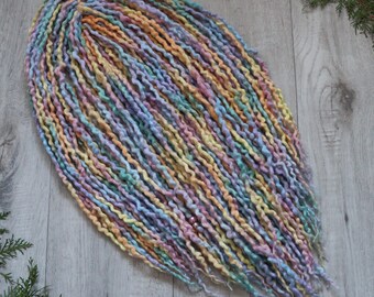 May include: A bundle of pastel-colored wool dreadlocks. The dreadlocks are a mix of light blue, pink, yellow, and green.