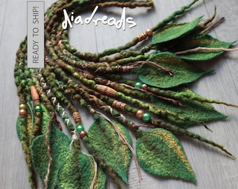 May include: A set of green and brown felted hair dreadlocks featuring attached felt leaves, wooden beads, and metallic accents. The text "diadreads" and "READY TO SHIP!" is visible on the image. The dreadlocks have a textured, twisted appearance.