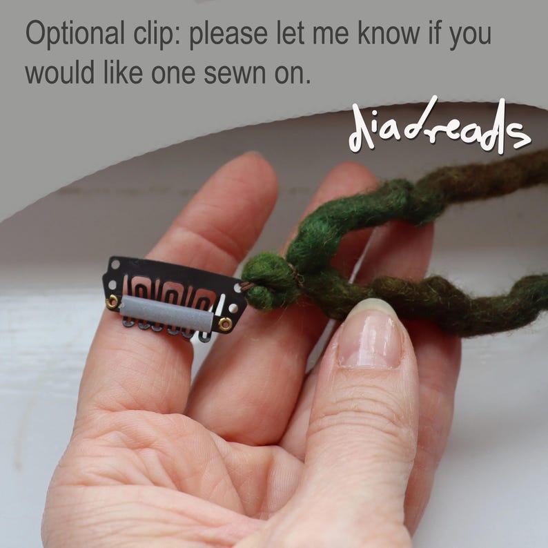 May include: A dark green felted dreadlock extension attached to a black metal snap clip with a grey silicone grip. The text reads: Optional clip: please let me know if you would like one sewn on. The brand name diadreads is visible.