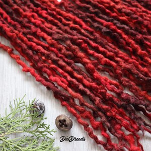 May include: Red and burgundy ombre synthetic dreadlocks. The dreadlocks are made of a soft, textured material and are perfect for adding a pop of color to any hairstyle.