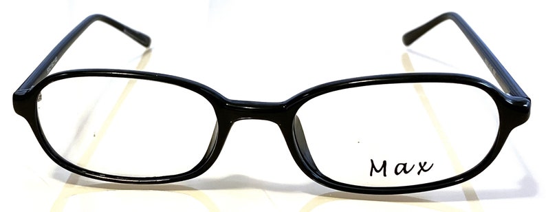 K&ouml;nnte beinhalten: Schwarze, ovale Brille mit dem Wort "Max" auf dem rechten Glas. Die Fassungen sind gl&auml;nzend und die B&uuml;gel sind d&uuml;nn. Die Brille ist vor einem wei&szlig;en Hintergrund platziert.