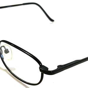 May include: Black metal frame eyeglasses with clear lenses. The glasses have a simple, classic design.