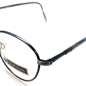 May include: Black metal framed eyeglasses with a silver accent on the temple arms. The brand name "David Hunter" is printed on the right lens.