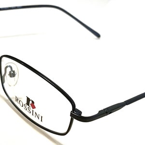May include: Black metal frame eyeglasses with clear lenses. The brand name "ROSSINI" is printed on the right temple.
