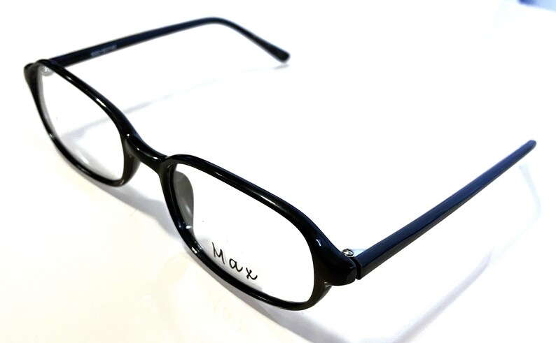 K&ouml;nnte beinhalten: Schwarze Brille mit rechteckigem Rahmen und abgerundeten Kanten. Die Brille hat ein schlankes, modernes Design mit dem Wort "Max" auf der Linse. Die B&uuml;gel sind d&uuml;nn und erstrecken sich nach hinten.