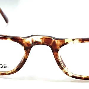 May include: Tortoiseshell eyeglasses with spring hinges. The glasses have clear lenses and the words "SPRING HINGE" are printed on the frame.