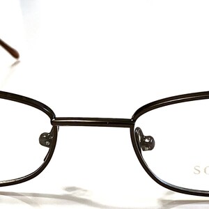 May include: A pair of black metal eyeglasses with a rectangular frame. The brand name "SORMANI" is printed on the right lens.