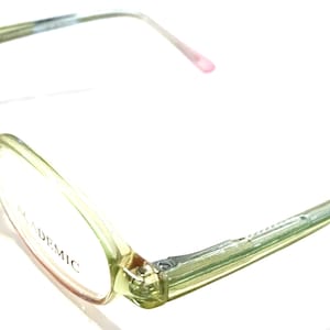 Könnte beinhalten: Eine grüne Brille mit klaren Gläsern und dem Wort "ACADEMIC" auf dem rechten Glas.