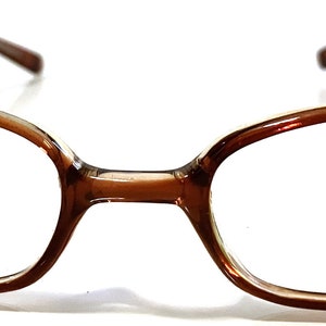 May include: Brown rectangular eyeglasses with a Max logo on the right lens.