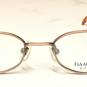 May include: A set of three ceramic mugs with a speckled, cream-colored glaze. Each mug features a different hand-painted design: a blue and green leaf, a yellow and orange flower, and a red and pink berry. The mugs have a simple, rounded shape.