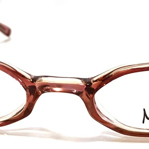 Könnte beinhalten: Eine Brille mit braunen, ovalen Gläsern und klaren Linsen. Der Markenname "Max" ist auf dem rechten Glas aufgedruckt.