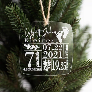 May include: Clear glass Christmas ornament with the text "Wyatt John Kleinert 07.22.2021 11:44am 7 pounds 4.3 ounces 19.25 inches" and a pair of baby footprints.