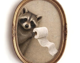 May include: An oval-shaped, ornate gold frame containing a print of a gray and black raccoon holding a roll of white toilet paper. The raccoon is positioned on the left side of the frame, looking forward against a neutral, textured beige background.