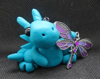 Teal dragon figurine with a purple dragonfly
