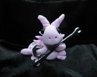 Pink worker dragon figurine with a wrench