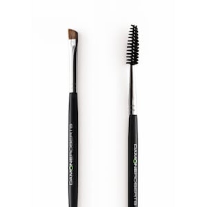 May include: A set of two black double-ended brow brushes with the brand name "DIAMONDS" printed on the handles. One brush has a spoolie on one end and an angled brush on the other. The other brush has a spoolie on one end and a small, flat brush on the other.