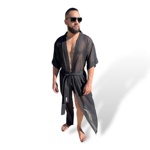 Op de afbeelding: Een zwarte, doorschijnende robe met een lang, vloeiend ontwerp. De robe heeft een riem met het woord "BOSS" erop gedrukt.