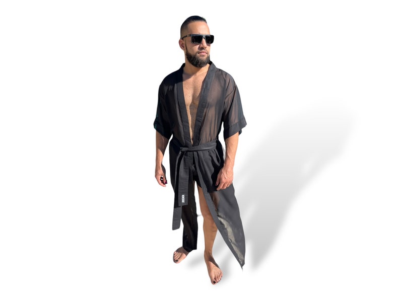 Op de afbeelding: Een zwarte, doorschijnende robe met een lang, vloeiend ontwerp. De robe heeft een riem met het woord "BOSS" erop gedrukt.