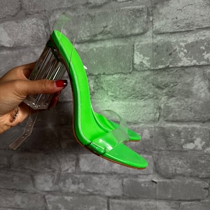 May include: Lime green high-heeled sandals with clear straps and a clear block heel.