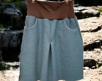 May include: A light blue skirt with a brown waistband. The skirt is hanging on a clothesline.