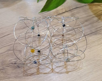 May include: A silver wire bracelet with multiple rings and colourful beads. The bracelet is made of thin wire and has a delicate, intricate design.