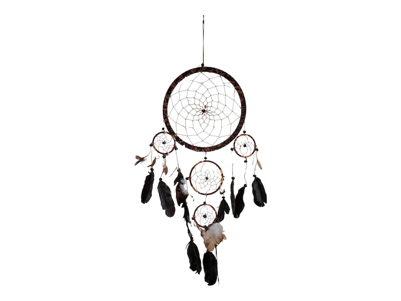 May include: A brown dreamcatcher with black feathers hanging from it. The dreamcatcher has a circular design with a web-like pattern and four smaller circles hanging from it.