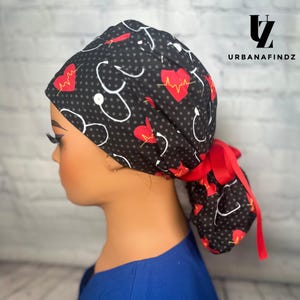 May include: Black and white scrub hat with red hearts and white stethoscopes. The hat has a red tie.  #urbanafindz
