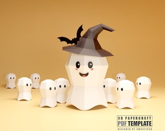 May include: A 3D papercraft Halloween-themed design featuring a smiling ghost wearing a witch hat and a bat. Surrounding the main figure are smaller ghost figures. The design is set against a warm, yellow background.