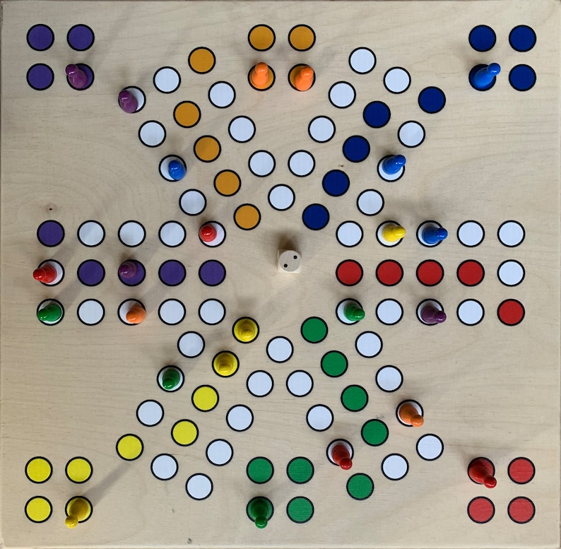 Puede incluir: Un tablero de juego de madera con un patr&oacute;n en forma de estrella de c&iacute;rculos de colores. El tablero tiene un c&iacute;rculo central con un dado de madera. Hay seis piezas de juego de diferentes colores en el tablero: rojo, azul, verde, amarillo, morado y naranja.