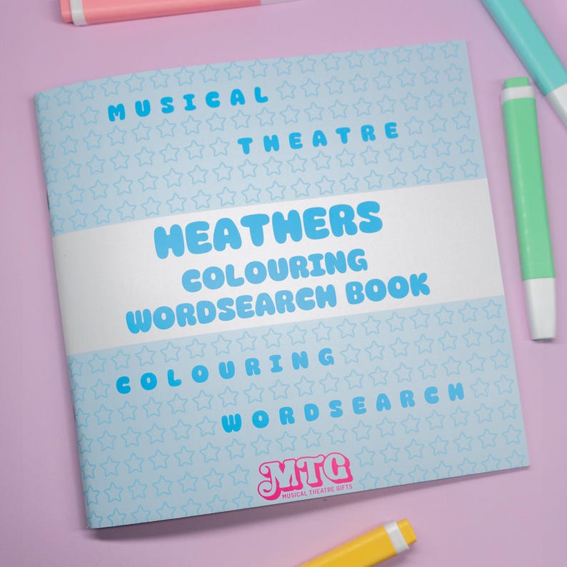 K&ouml;nnte beinhalten: Ein "Heathers" Mal- und Suchselbuch mit dem Text "Musical Theatre" in Hellblau. Das Buch hat einen hellblauen Sternmusterhintergrund und den Text "Colouring Wordsearch Book". Das Logo "MTC Musical Theatre Gifts" befindet sich unten.
