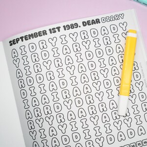 K&ouml;nnte beinhalten: Ge&ouml;ffnete Tagebuchseite mit dem Text "SEPTEMBER 1ST 1989. DEAR DIARY" in einer Blasen-Schriftart. Ein gelber Textmarker liegt auf der Seite. Das Tagebuch ist ein Geschenk f&uuml;r das Musiktheater.