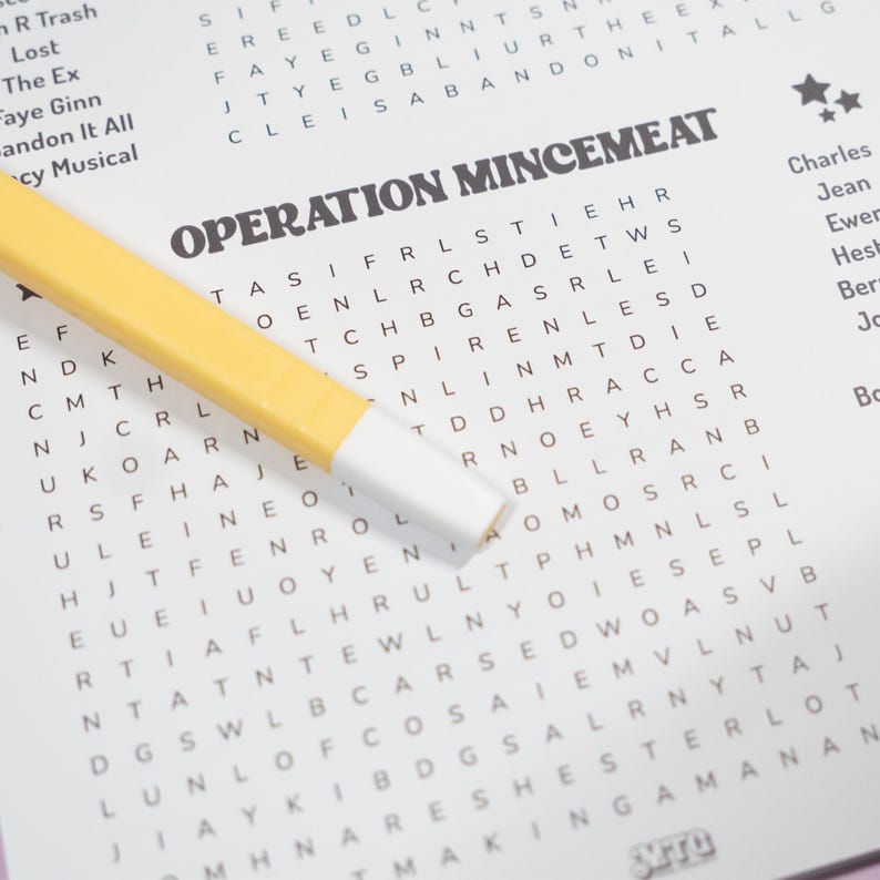 May include: A yellow highlighter with a white tip rests on a crossword puzzle titled "OPERATION MINCEMEAT." The puzzle is filled with letters, and the text "OPERATION MINCEMEAT" is printed in bold, black letters.