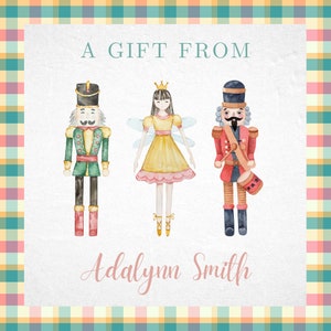 May include: A watercolor illustration of a Nutcracker, a fairy, and a Nutcracker holding a drum. The text "A Gift From Adalynn Smith" is below the illustration.