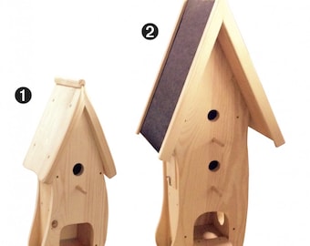 Op de afbeelding: Twee houten vogelhuisjes, een met een dak van shingles en de andere met een simpel dak. Het vogelhuisje met het dak van shingles heeft drie toegangsgaten, terwijl de andere er één heeft. Beide vogelhuisjes hebben een uniek, gebogen ontwerp.