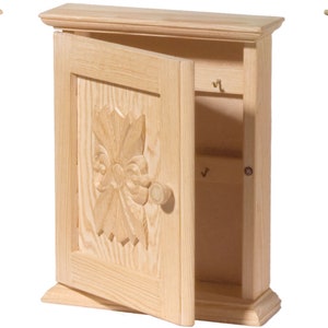 Puede incluir: Tres armarios de llaves de madera con diferentes dise&ntilde;os. El primer armario tiene un dise&ntilde;o floral tallado, el segundo tiene un dise&ntilde;o de flor tallada y el tercero tiene un dise&ntilde;o de celos&iacute;a.