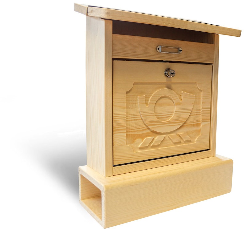 Puede incluir: Un buz&oacute;n de madera con una tapa abatible y un dise&ntilde;o de caracol tallado. El buz&oacute;n tiene un peque&ntilde;o caj&oacute;n y una cerradura. El buz&oacute;n est&aacute; montado sobre una base de madera.