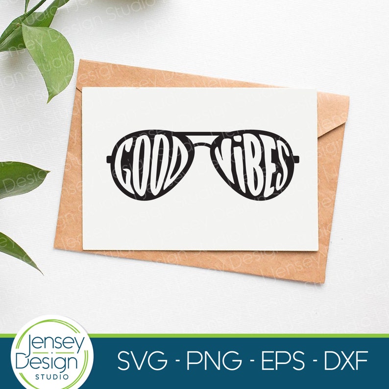 May include: A white card with a black graphic of sunglasses with the word "GOOD VIBES" written inside the lenses. The card is on a brown envelope.