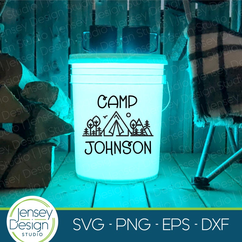 May include: A white plastic bucket with a blue glow, featuring a black silhouette of a tent, trees, and mountains with the text "CAMP JOHNSON" on it.