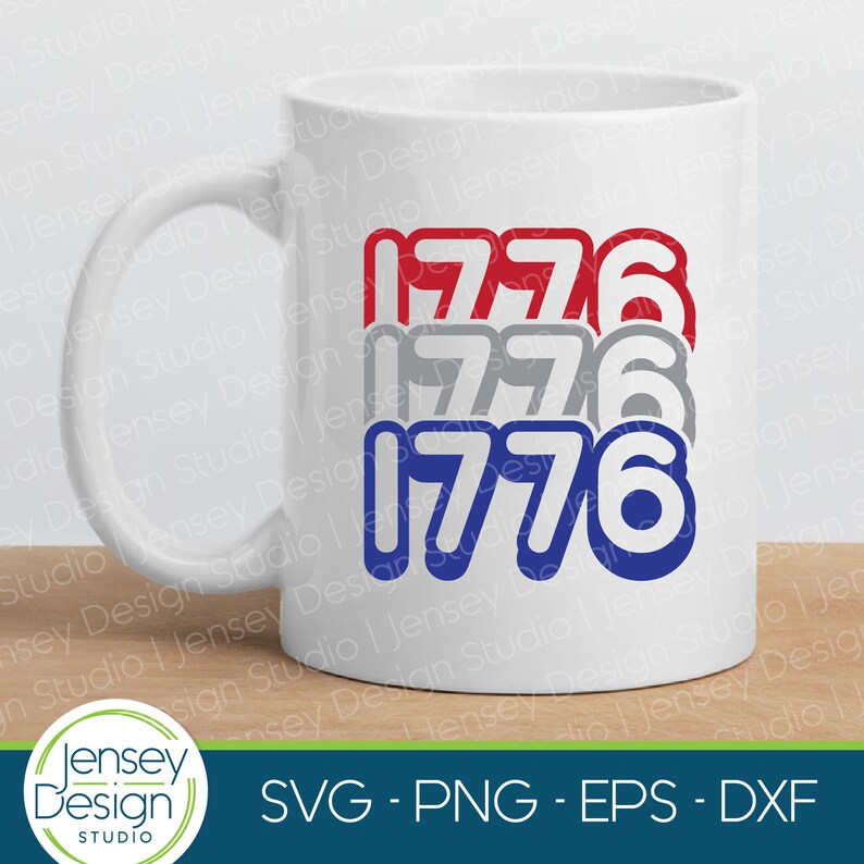 Może przedstawiać: Biały kubek ceramiczny z nadrukiem liczby 1776 powt&oacute;rzonej trzykrotnie w kolorze czerwonym, szarym i niebieskim. Liczby są w pogrubionym, zaokrąglonym kroju pisma. Kubek stoi na drewnianej powierzchni.