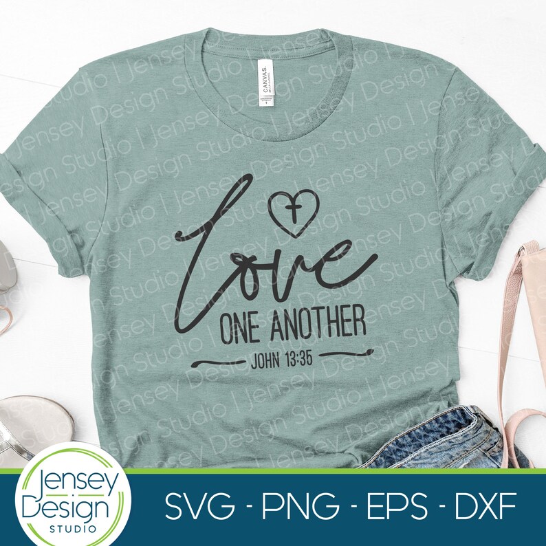 May include: A light green t-shirt with the words "Love One Another" in a black script font, with a heart and cross symbol above the word "Love". The text "John 13:35" is below. The shirt also has the text "SVG - PNG - EPS - DXF".