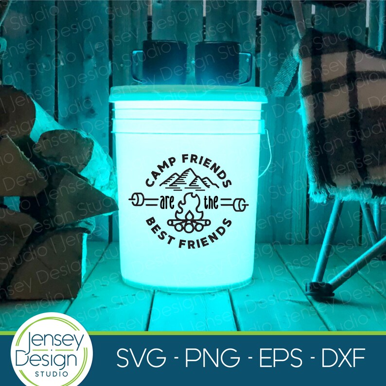 Pu&ograve; includere: Un secchio bianco con una grafica nera che dice "Camp Friends are the Best Friends" con un fal&ograve; e montagne nel design. Il secchio &egrave; illuminato dall'interno con una luce blu.