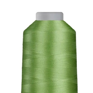 May include: A spool of green embroidery thread on a white plastic bobbin.