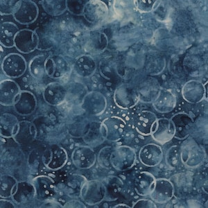 May include: A close-up of a fabric with a blue and white watercolor design. The fabric features overlapping circles and small dots in white against a dark blue background. The pattern creates a textured, abstract look.
