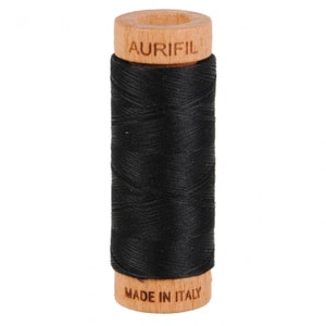 May include: A spool of black thread with a wooden bobbin. The bobbin is labeled "Aurifil" and "Made in Italy".