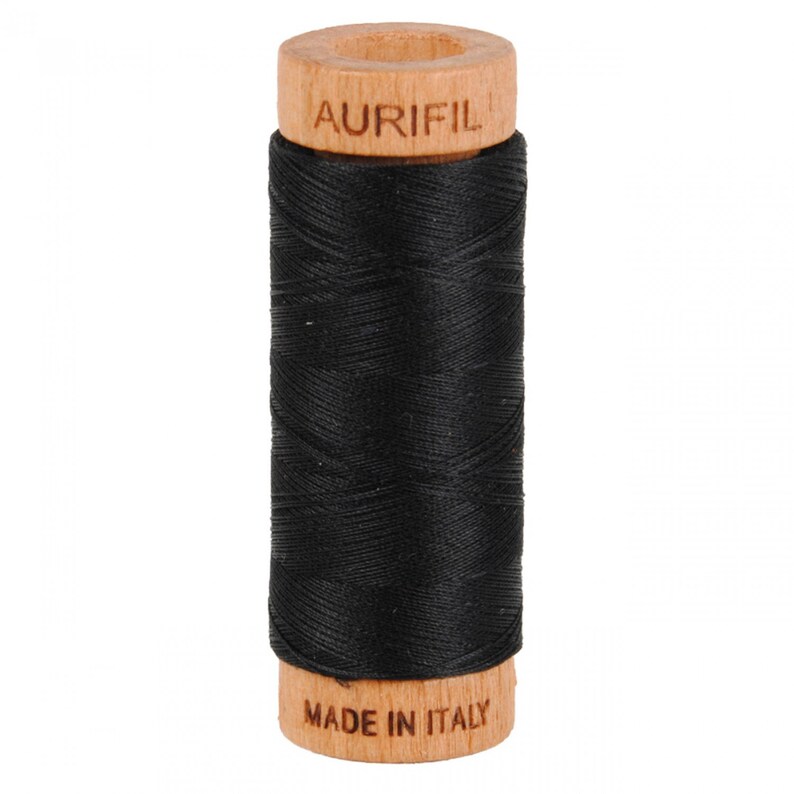 May include: A spool of black thread with a wooden bobbin. The bobbin is labeled "Aurifil" and "Made in Italy".